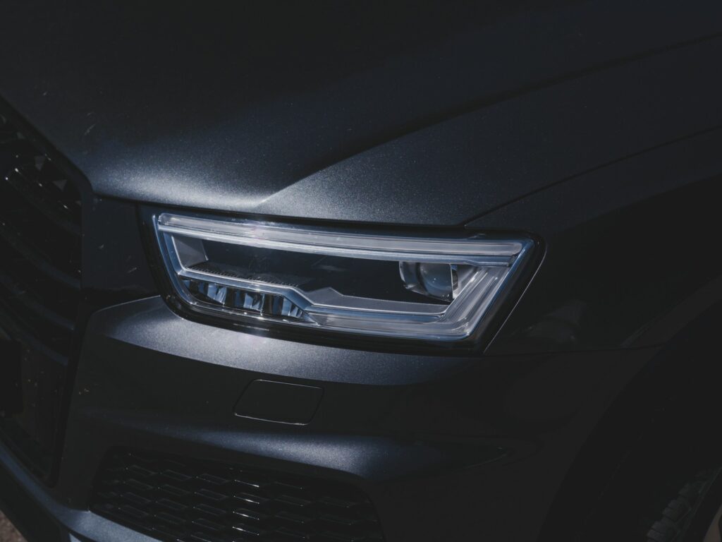 A close-up of a dark car headlight — illustrative photography