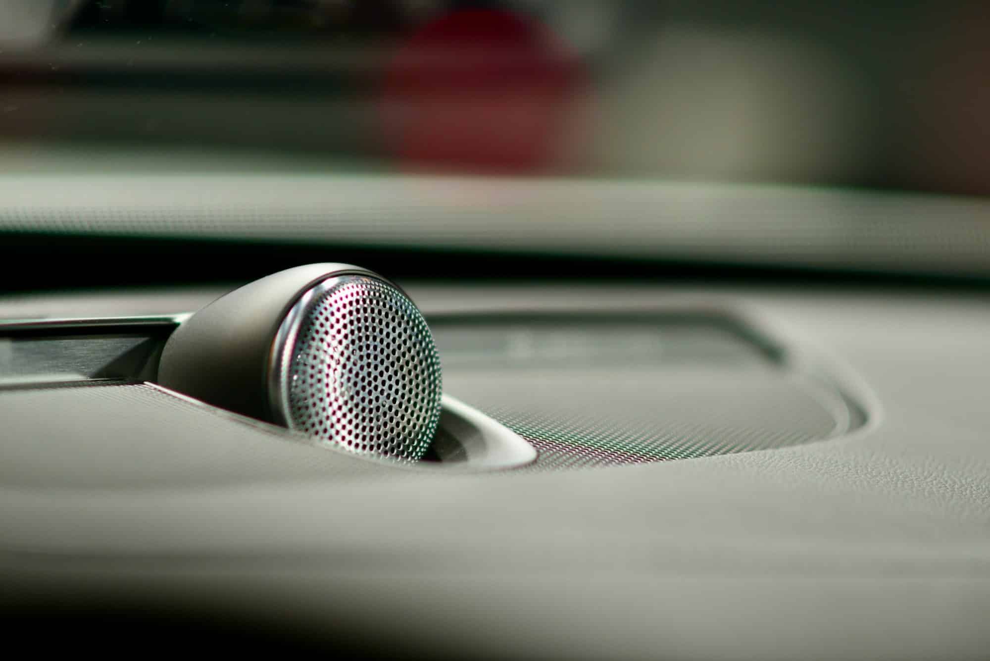 A close up of a speaker on a car dashboard — illustrative photography